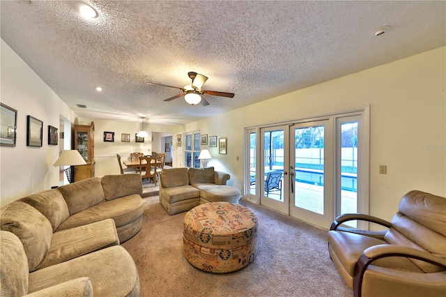 living room with carpet floors, ceiling fan, french doors, and a textured ceiling