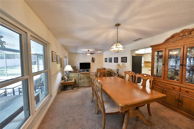 dining area featuring ceiling fan with notable chandelier, carpet, and a textured ceiling