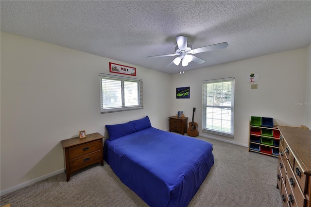 carpeted bedroom with ceiling fan, a textured ceiling, and multiple windows