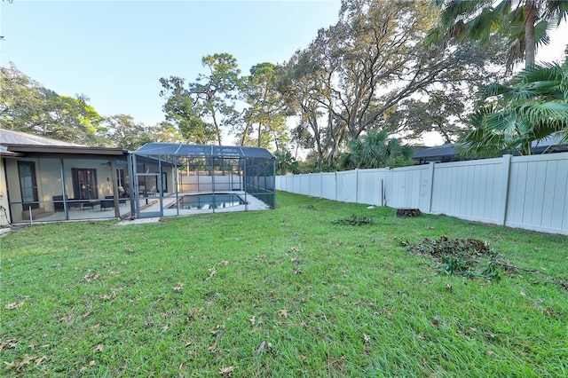 view of yard with glass enclosure and a fenced in pool