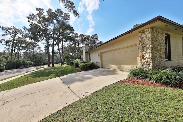 view of side of property featuring a garage and a lawn