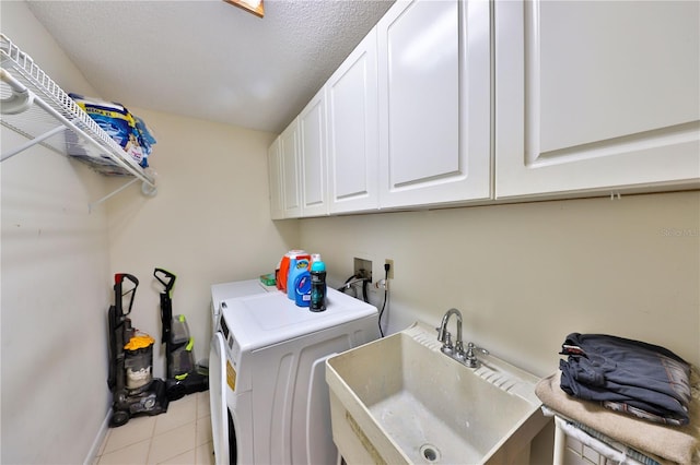 laundry room with cabinets, a textured ceiling, sink, and washer and dryer