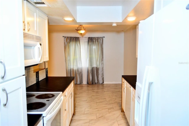 kitchen with decorative light fixtures, white cabinetry, white appliances, and a skylight