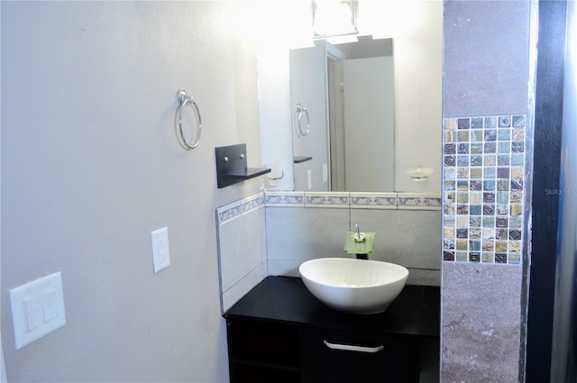 bathroom featuring vanity and tile walls