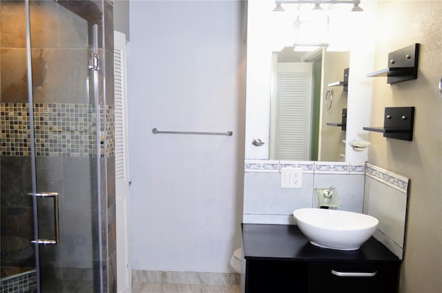 bathroom featuring vanity, toilet, and a shower with shower door