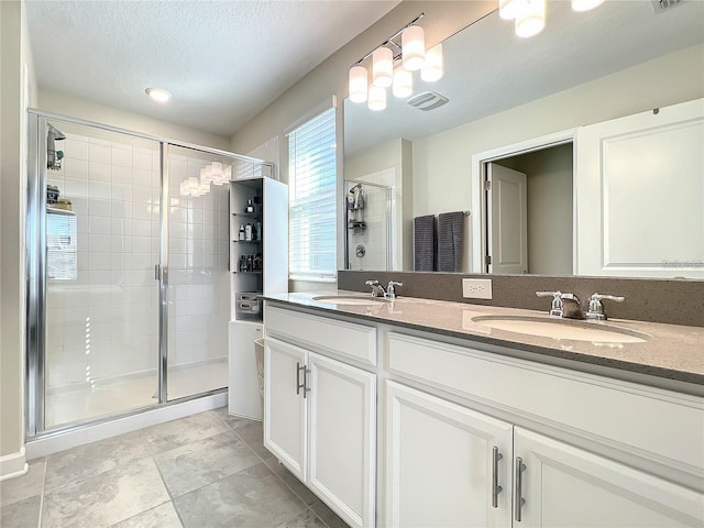 13041 Inkwell Aly, Winter Garden, FL 34787 - full bathroom with visible vents, a sink, double vanity, and a stall shower