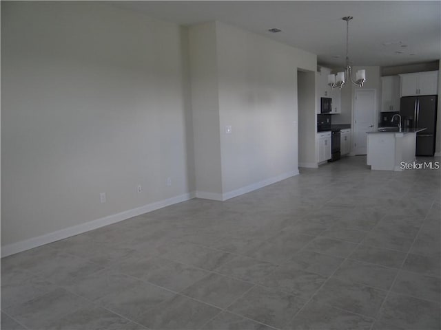 unfurnished living room with light tile patterned floors, sink, and a chandelier