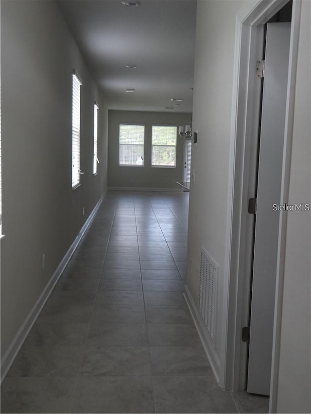 hallway featuring dark tile patterned floors