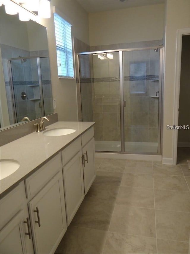 bathroom featuring tile patterned floors, an enclosed shower, and vanity