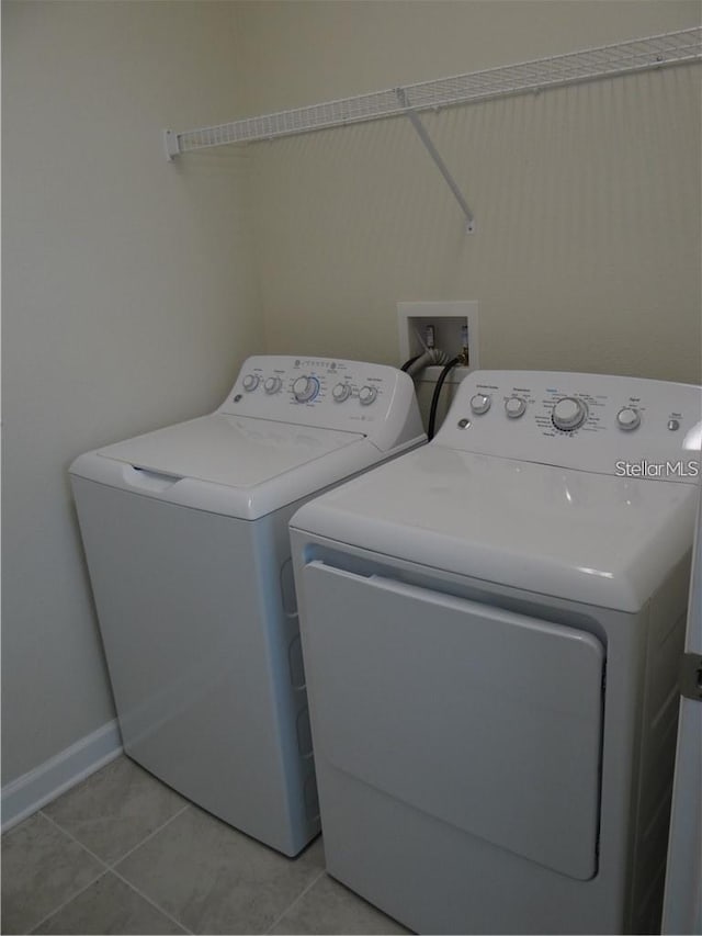 laundry area featuring light tile patterned floors and washer and dryer