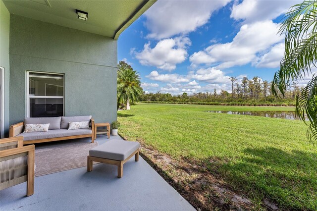 view of yard with a water view, an outdoor living space, and a patio area