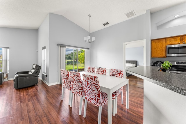 dining space with dark hardwood / wood-style floors, high vaulted ceiling, a chandelier, and a textured ceiling