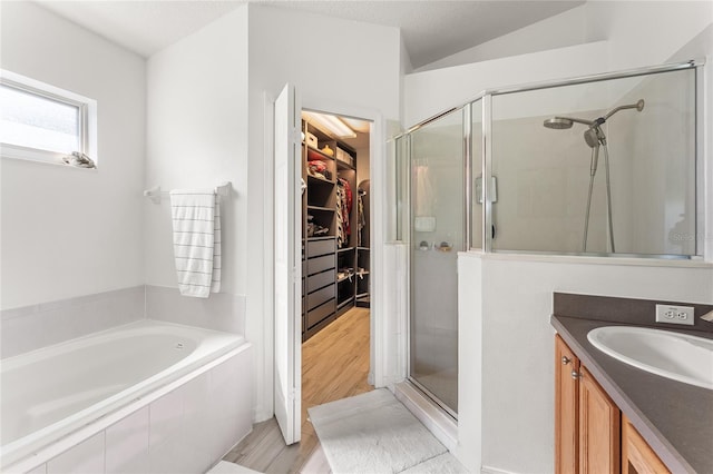 bathroom featuring hardwood / wood-style flooring, lofted ceiling, vanity, and independent shower and bath