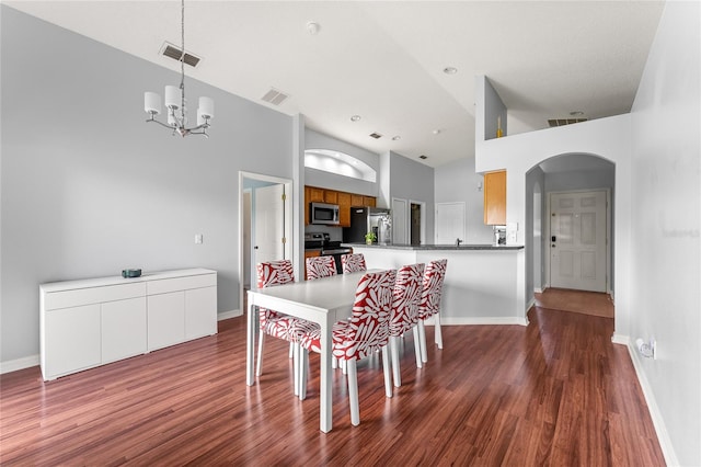 dining space with dark hardwood / wood-style floors, high vaulted ceiling, and a chandelier