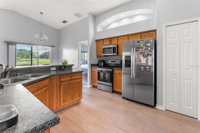 kitchen with light hardwood / wood-style floors, an inviting chandelier, sink, hanging light fixtures, and appliances with stainless steel finishes