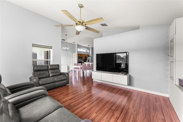 living room with ceiling fan with notable chandelier, high vaulted ceiling, and hardwood / wood-style flooring