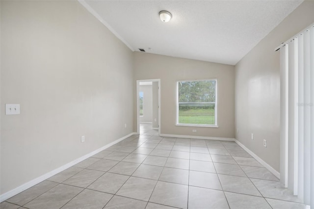 unfurnished room with light tile patterned floors, a textured ceiling, and vaulted ceiling