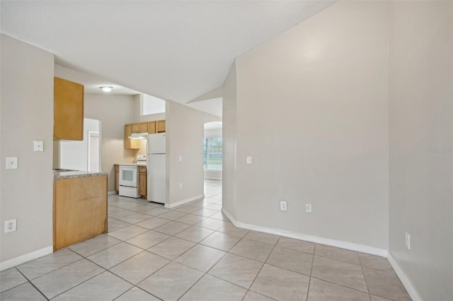 kitchen with lofted ceiling, light tile patterned floors, and white appliances