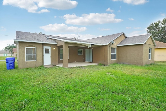 rear view of property featuring a yard and a patio area