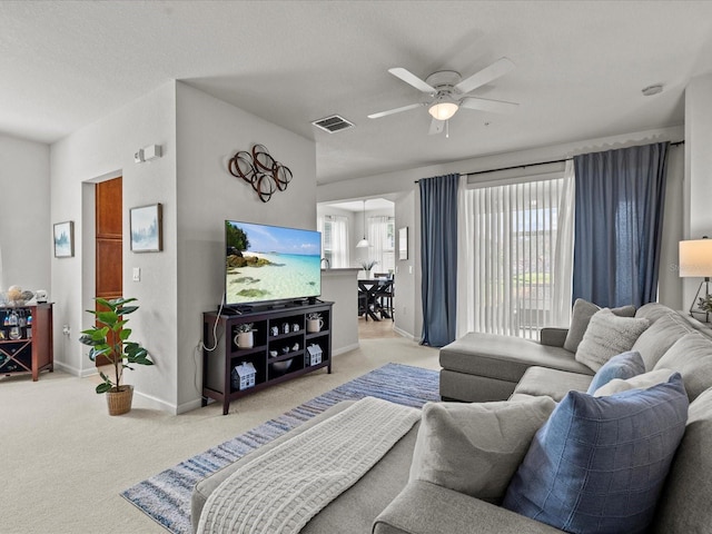 carpeted living room featuring ceiling fan