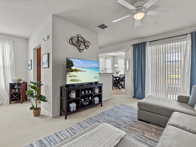 living room featuring light colored carpet and ceiling fan