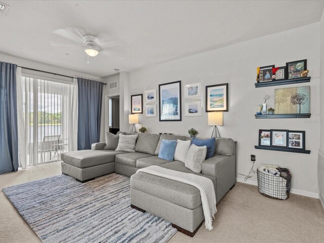 carpeted living room with ceiling fan