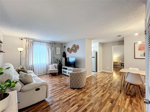 living room with wood-type flooring and a textured ceiling