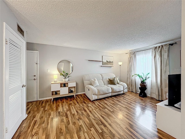 living room featuring a textured ceiling and hardwood / wood-style flooring