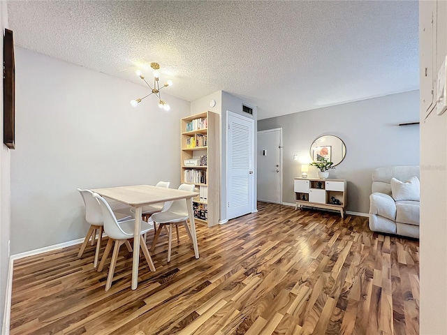 dining room featuring a notable chandelier, a textured ceiling, and wood-type flooring