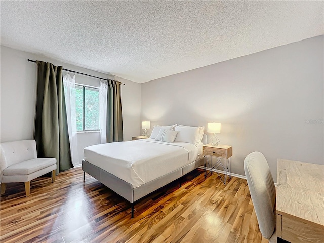 bedroom with hardwood / wood-style flooring and a textured ceiling