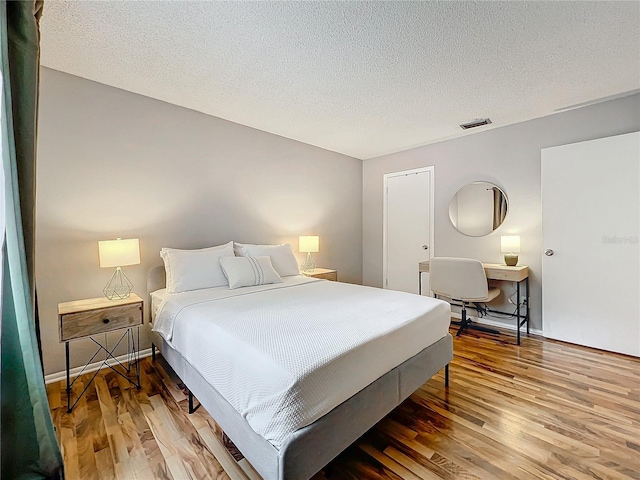 bedroom featuring hardwood / wood-style floors and a textured ceiling