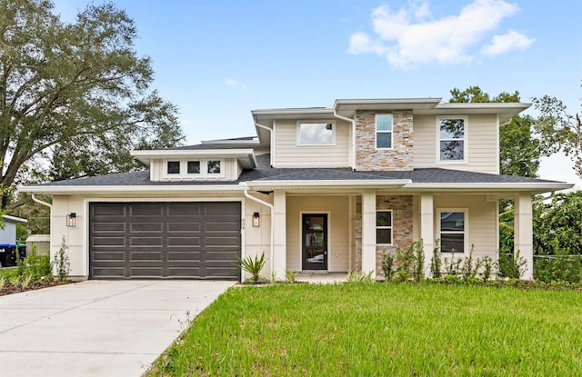 prairie-style house featuring a front lawn and a garage