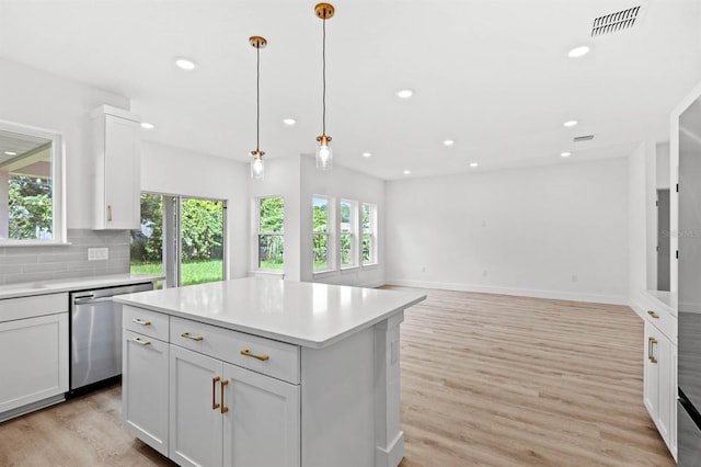 kitchen with stainless steel dishwasher, light hardwood / wood-style flooring, and a healthy amount of sunlight