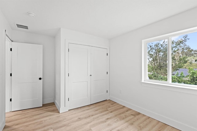 unfurnished bedroom featuring a closet and light hardwood / wood-style floors