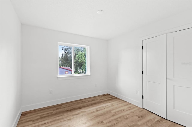 unfurnished bedroom featuring a closet and light wood-type flooring