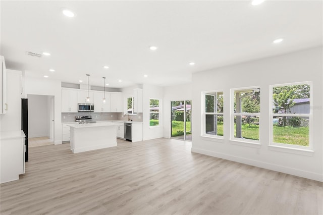 634 Burch Ave, Winter Garden, FL 34787 - unfurnished living room with plenty of natural light, recessed lighting, light wood-style floors, and a sink