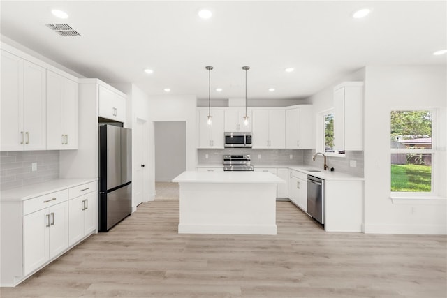 634 Burch Ave, Winter Garden, FL 34787 - kitchen with appliances with stainless steel finishes, a sink, decorative backsplash, recessed lighting, and a kitchen island