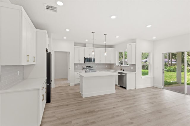 634 Burch Ave, Winter Garden, FL 34787 - kitchen featuring appliances with stainless steel finishes, a sink, decorative backsplash, a kitchen island, and recessed lighting