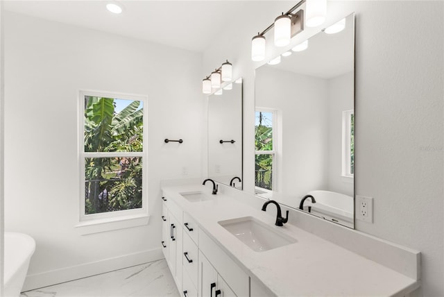 634 Burch Ave, Winter Garden, FL 34787 - full bath with marble finish floors, double vanity, a freestanding tub, baseboards, and recessed lighting