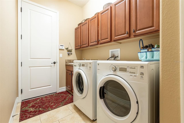 clothes washing area with cabinets, separate washer and dryer, and light tile patterned floors