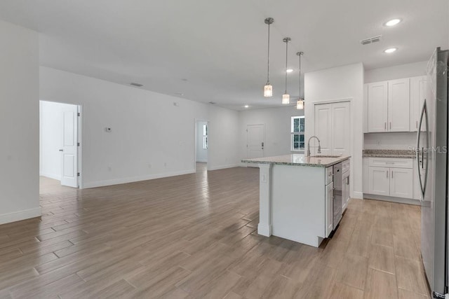 kitchen featuring light hardwood / wood-style floors, white cabinetry, and stainless steel refrigerator