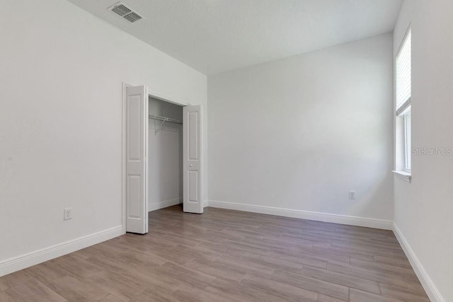 unfurnished bedroom with light hardwood / wood-style floors and a closet