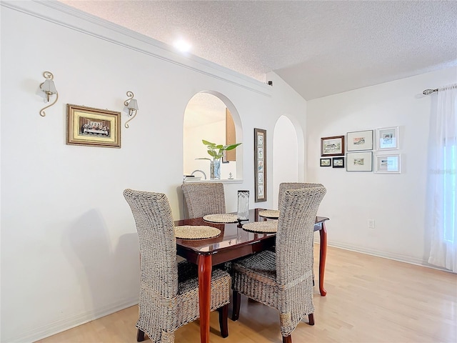 dining space with a textured ceiling and light wood-type flooring