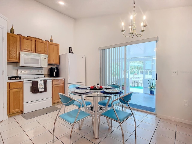 kitchen featuring hanging light fixtures, white appliances, a notable chandelier, light tile patterned floors, and high vaulted ceiling