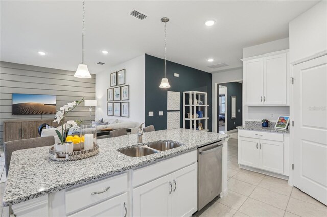 kitchen with hanging light fixtures, sink, a kitchen island with sink, white cabinetry, and dishwasher