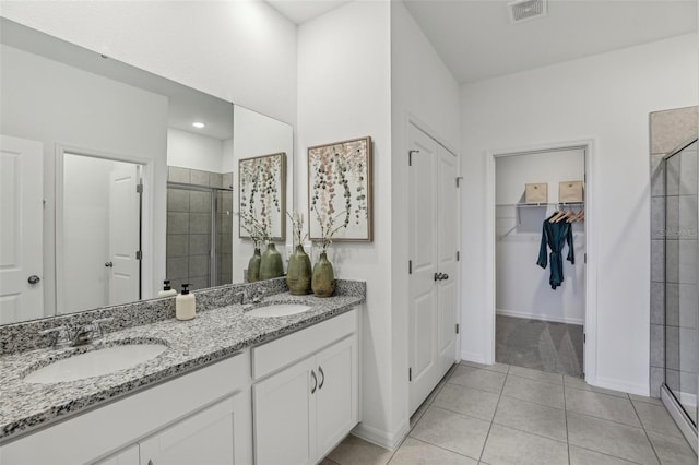 bathroom with walk in shower, tile patterned floors, and vanity