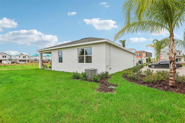 view of home's exterior with a yard and central AC