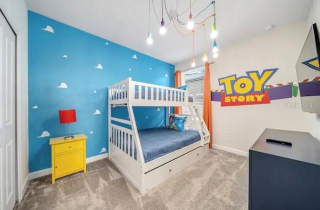 bedroom featuring a notable chandelier and carpet floors