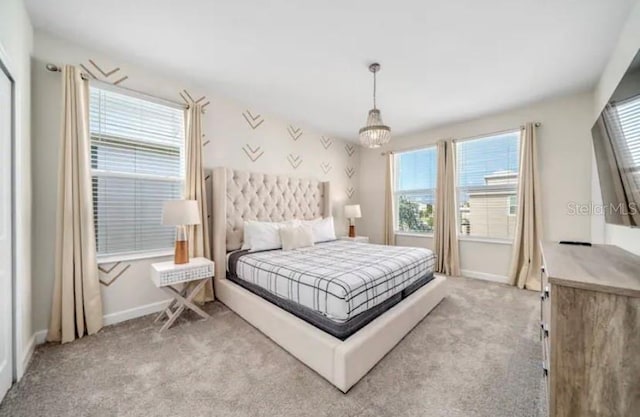 carpeted bedroom featuring a chandelier