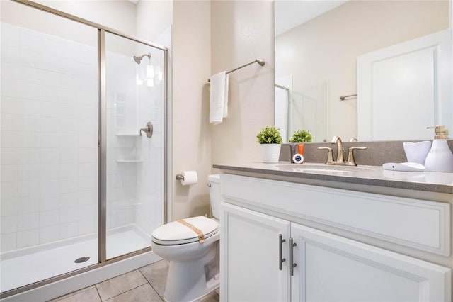 bathroom featuring vanity, tile patterned flooring, toilet, and a shower with door